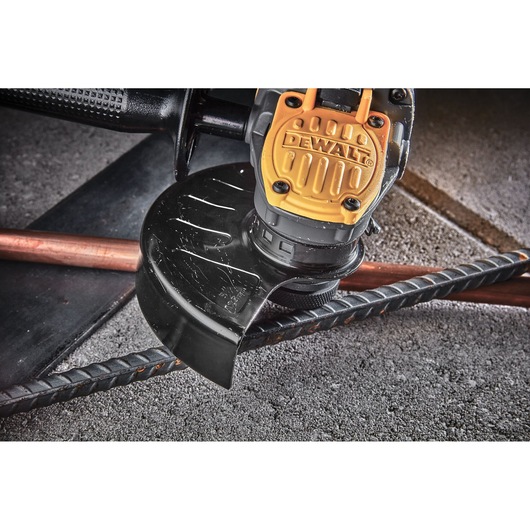 Close view of Brushless 18V XR 125mm cordless angle grinder head sitting amongst rebar and copper piping