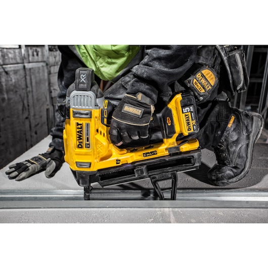 Cordless Concrete Nailer being used by a person installing drywall track.